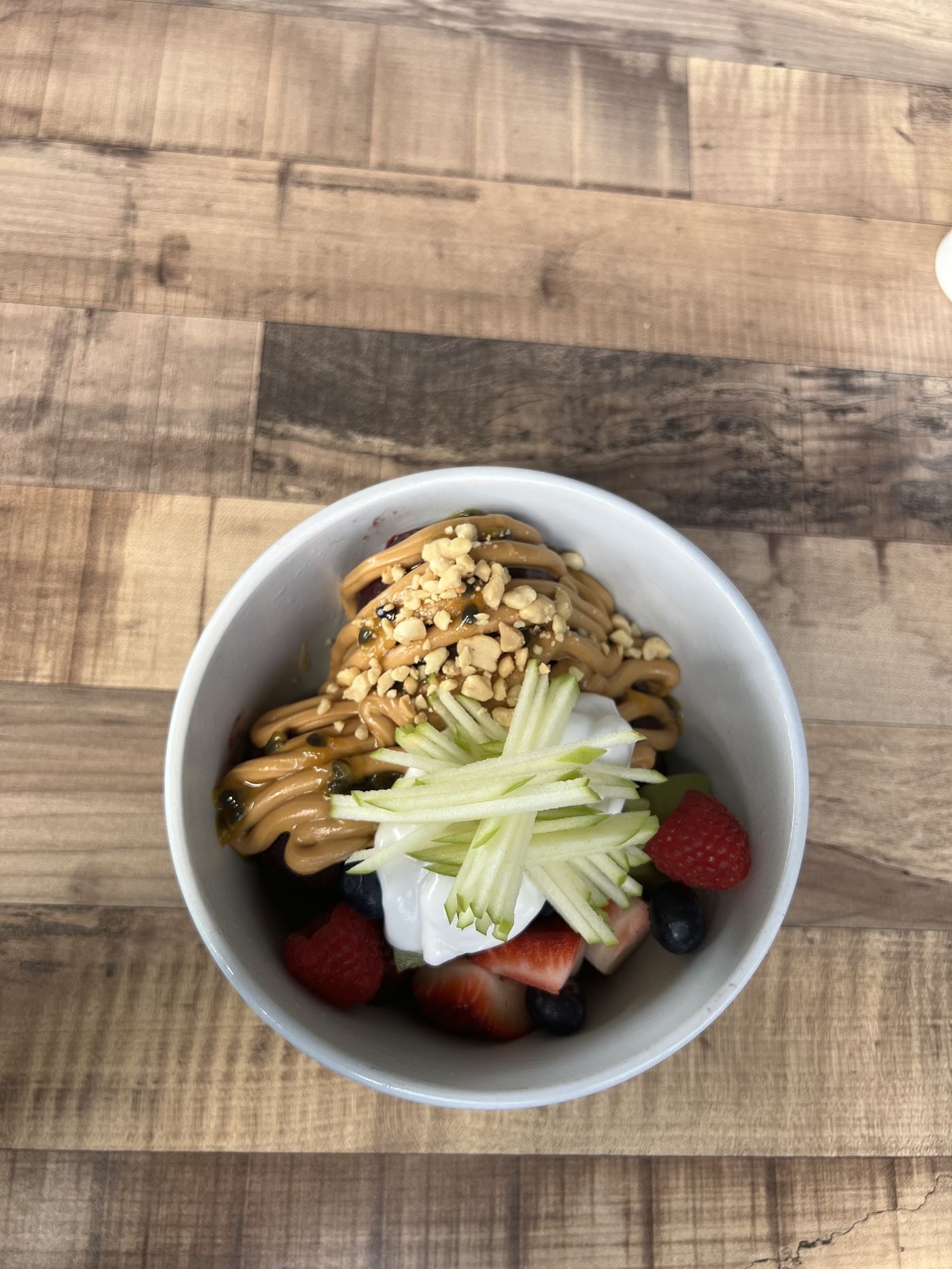 Fruit bowl with berries, yoghurt, apple and peanut butter